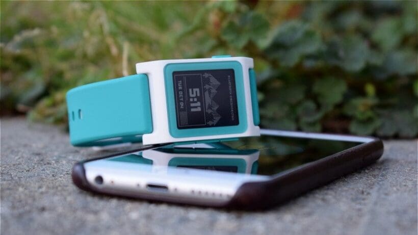 smartwatch lying on top of iPhone