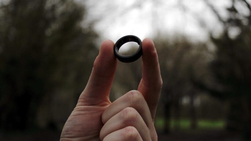smart ring held up in forest