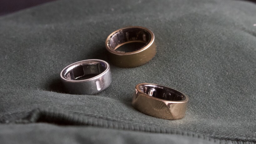 three smart rings pictured together on a neutral surface